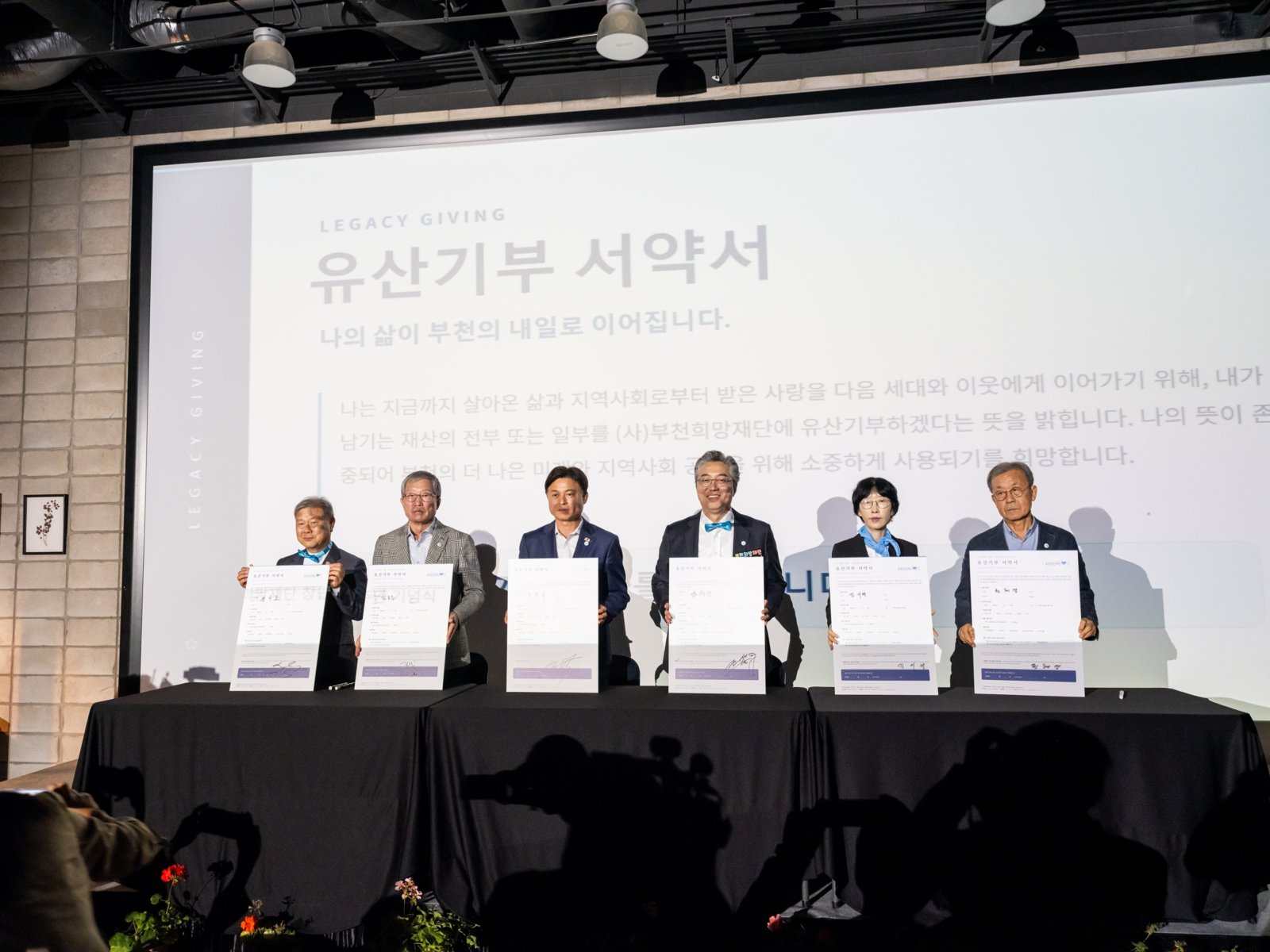 시민 대표 참여자들이 서명한 유산기부 서약서를 들어 보이는 모습